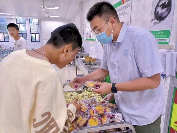 扬子餐饮张俊经理为学生发放月饼.jpg